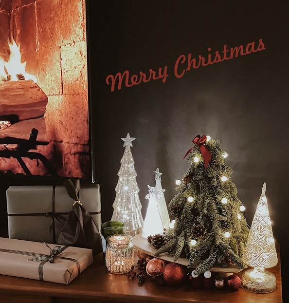 glass glowing Christmas tree and candle